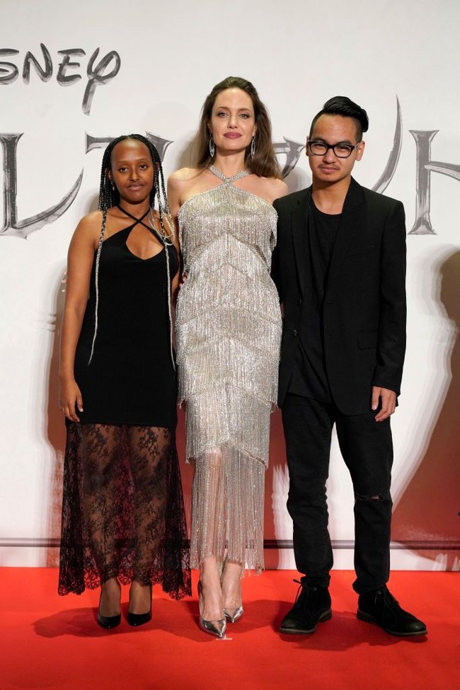 Di Jepang, gaun penuh detail fringe menjadi andalan Angelina Jolie yang datang bersama Zahara dan Maddox. Gaun tersebut hadir dengan gaya halter neck yang senada dengan gaun putrinya. (Foto: Getty Images)