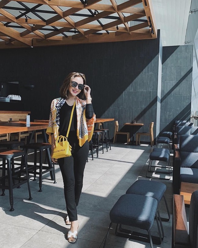 Bergaya saat tiba di Entikong, Kalimantan Barat, Cita Citata memadukan outer batik dengan sling bag Balenciaga berwarna senada. Tas berwarna kuning seri Balenciaga canary yellow Ville XXS tersebut pada situs belanja Farfecth dijual seharga US$ 2.010. Foto: Instagram @ cita_citata