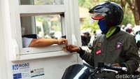 Seorang pengendara sepeda motor membayar biaya parkir di salah satu tempat parkir di Jakarta, Selasa (8/10/2019).