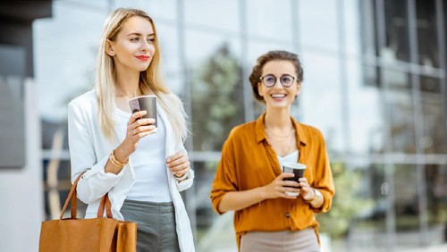 Group of business people working together on business project.  Young secretary woman and financial advisor businessman sitting in front of laptop while middle aged executive professional woman standing behind them and giving advice.
