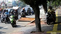 Terlihat seorang pemotor nekat melintasi trotoar untuk menghindari lubang galian yang berada di pinggir jalan.