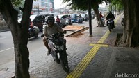 Sejumlah pemotor nekat melintasi trotoar saat berkendara di kawasan Jalan Otista, Jakarta, Rabu (9/10/2019).