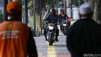Sejumlah pemotor terlihat melintasi trotoar di Jalan Otista, Jakarta