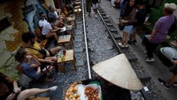 Sejumlah wisatawan nampak asyik duduk-duduk sambil menikmati makanan dan minuman di kafe yang berada persis di pinggir rel kereta api yang berada di kawasan Hanoi, Vietnam.
