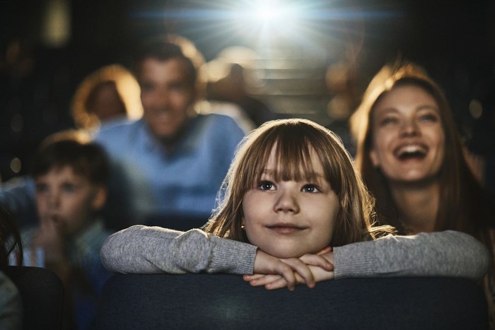 Close up of a young family enjoying a movie in the cinema