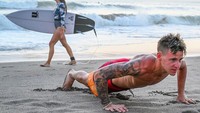 Tak cuma berenang di home stay-nya, rookie MotoGP 2019 itu juga bermain ke pantai. Dengan santai pebalap 20 tahun itu push up di tepi pantai, saat di sekitarnya justru banyak yang bermain selancar. (Foto: Instagram @fabioquartararo20)