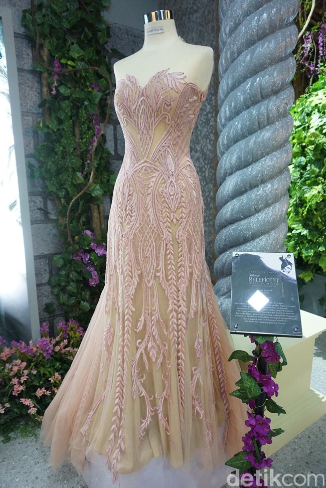 Gaun berwarna merah muda karya Albert Yanuar ini terinspirasi dari kisah Putri Aurora yang identik dengan kepribadian ceria dan hangat. Gaun yang diberi nama Briar Roseitu memiliki bordiran hampir di seluruh bagian furing luarnya. Warna-warna cerah dan lembut dipilih untuk mencerminkan kemurnian hati yang dimiliki oleh Putri Aurora dalam film Maleficent. Bordiran pada gaun melambangkan Putri Aurora yang bertumbuh sebagai sosok kuat dan tabah dalam pencariannya untuk menemukan cinta sejati. Foto: Vina Oktiani/Wolipop