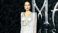 Mantan istri Brad Pitt itu memilih tampil dengan dress panjang menyapu lantai berwarna putih ombre. Tim P. Whitby/Getty Images