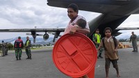 Seorang pengungsi bersama anaknya menuruni pesawat hercules TNI AU saat tiba di Bandara Wamena, Kabupaten Jayawijaya, Papua, Kamis (10/10/2019).