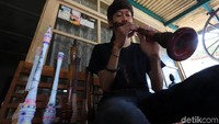 Ardi (23) sedang memainkan alat musik tradisional hasil buatan di Desa Tarajusari, Kecamatan Banjaran, Kabupaten Bandung, Jmat (11/10/2019).