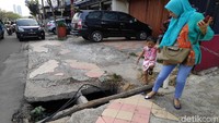 Pejalan kaki melintas di trotoar berlubang di kawasan Margonda, Depok, Jumat (11/10/2019).
