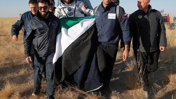Tampak Hazza membawa bendera UAE. Ia terpilih dari 4.000 kandidat dan sebelum terbang dilatih intensif di Rusia di Yuri Gagarin Cosmonaut Training Centre. Foto: Reuters