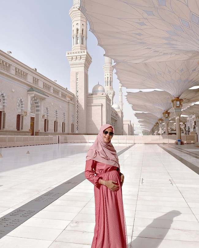 Pada umrah perdananya bersama Baim Wong, Paula tampil cantik berhijab. Kehamilannya sudah memasuki usia tujuh bulan, top model Indonesia itu memakai dress pink dan hijab segiempat yang ia bentuk menutupi dada. Foto: instagram @paula_verhoeven
