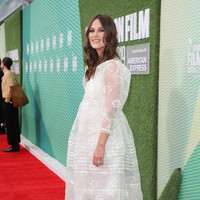 Sebagai penyempurna gaya, Keira memadukan gaun tersebut heels berwarna emas. (Foto: Getty Images)