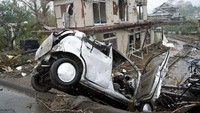 Penampakan sebuah mobil dan rumah yang mengalami kerusakan cukup parah di kawasan Ichihara, Prefektur Chiba, Jepang, Sabtu (12/10/2019). Katsuya Miyagawa/Kyodo News via AP.
