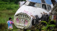 Bangkai pesawat yang telantar ini telah tertutupi oleh banyak coretan graffiti dengan jendela yang sudah rusak (AFP)