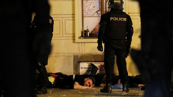 Soccer Football - Euro 2020 Qualifier - Group A - Fans gather in Prague for Czech Republic v England - Prague, Czech Republic - October 11, 2019  Fans lie on the floor of a street as a police officer looks on before the match  REUTERS/Bernadett Szabo