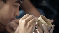 Seorang pelajar dengan teliti mengikuti workshop membuat gerabah berbahan dasar tanah liat.