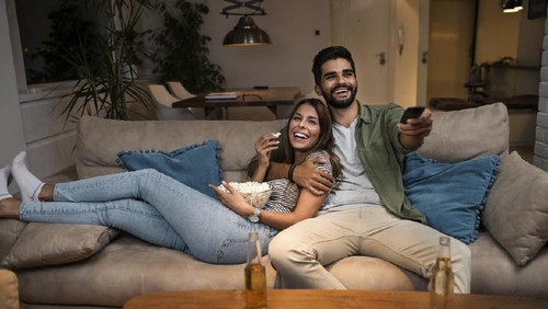 Cropped shot of an affectionate couple watching a movie at home