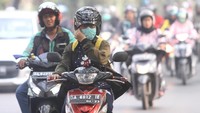Pengendara sepeda motor menggunakan masker pelindung pernapasan saat melintas di Jalan Brig Jend Hasan Basri yang diselimuti kabut asap di Banjarmasin, Kalimantan Selatan, Senin (14/10/2019).