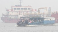 Sebuah kapal feri tradisional terlihat melintas di Sungai Barito yang diselimuti kabut asap di Banjarmasin, Kalimantan Selatan, Senin (14/10/2019).