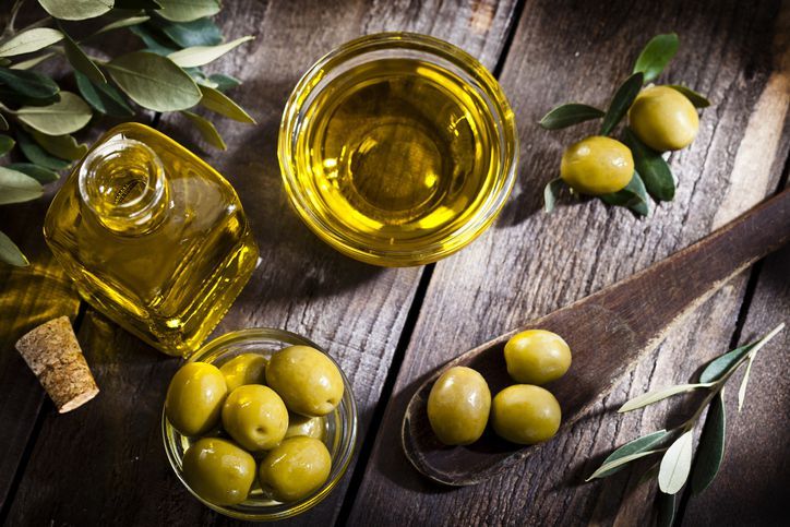 Olives assortment in bowl with oil. Top view. Copy space