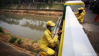 Bekerja di pinggir kali, petugas ini harus ektra hati-hati.