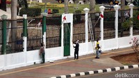Pagar besi dicat warna hitam sementara temboknya dipoles warna putih.