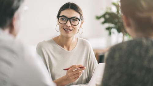 Shot of a smiling young couple talking together while relaxing in their living room