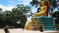 Seorang wanita Buddha berlutut di depan Patung Buddha berukuran besar di kawasan UFO ini. Sebelum mendapat kisah dari keluarga Wassana yang melihat alien, tempat ini tidak dikaitkan dengan UFO. (CNN Travel)  
