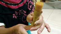Banyak orang memulai makan clorot dari atas. Padahal yang benar dari bagian bawah. Ditekan hingga kuenya naik ke atas dan siap disantap. Foto: Rinto Heksantoro /detikcom