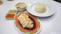 ni menu Poached Chicken Rice Set (Rp 45.000), yang terdiri dari nasi Hainan,  kaldu, dan ayam rebus. Berupa irisan daging dada ayam negeri yang utuh, disajikan dengan saus kecap asin dan campuran minyak wijen, serta racikan bumbu rahasia Wancan dan mentimun di bawahnya. Foto: dok. detikFood