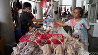 Seorang warga tengah membeli daging ayam dari salah satu pedagang yang mulai berjualan di kios yang berada di bawah Rusunawa Pasar Rumput, Jakarta.
