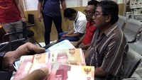 Polisi menunjukkan sejumlah pelaku dan barang bukti saat rilis penangkapan pelaku judi Pemilihan Kepala Desa (Pilkades) di Mapolres Blitar Kota, Jawa Timur, Selasa (15/10/2019) malam. Satgas Anti Judi Pilkades berhasil mengamankan tiga pelaku serta sejumlah barang bukti dan uang tunai Rp 27 juta. ANTARA FOTO/Irfan Anshori.
