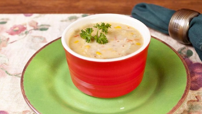 Bown of homemade corn chowder soup with parsley garnish.
