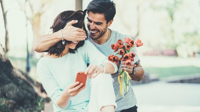 Man surprising his girl with flowers