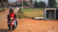 Warga melintas di lokasi pembangunan Jalan Lingkar Majalaya.