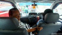Seorang warga menggunakan angkot ber-AC untuk beraktivitas sehari-hari.