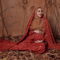 Masih dalam balutan busana Barli Asmara, Kartika Putri berpose didampingi sang suami dengan latar dedaunan kering dan ranting. Foto: instagram @mariophotographie