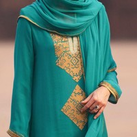 Ibu tiga anak ini mengenakan baju tradisional Pakistan yang disebut shalwar kameez. Baju dengan model tunik dengan bordiran emas itu ia pasangkan dengan celana berwarna sama. Foto: Owen Humphreys - Pool/Getty Images