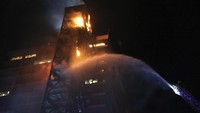 Dalam kerusuhan di Santiago itu, setidaknya 16 bus dibakar massa dan 12 stasiun kereta hancur total. Dalam foto ini, kobaran api muncul di gedung Enel Energy Europe yang dibakar massa (Foto: AP)