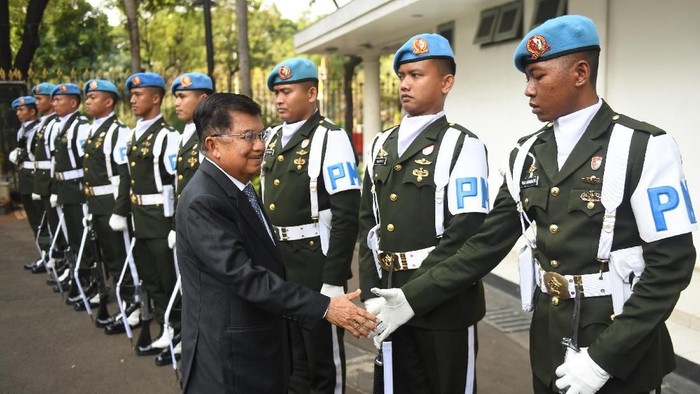 Wakil Presiden Jusuf Kalla (kiri) berjabat tangan dengan anggota Pengawal Istana dari satuan Yonwalprotneg Paspampres sebelum meninggalkan Istana Wakil Presiden pada hari terakhirnya bertugas di Jakarta, Sabtu (19/10/2019). Jusuf Kalla mengatakan akan menghabiskan waktu dengan keluarga serta aktif berkegiatan sosial usai purnatugas sebagai wakil presiden. ANTARA FOTO/Akbar Nugroho Gumay/ama.