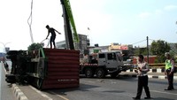 Petugas membantu evakuasi truk peti kemas dengan nopol BK 8290 CI yang terguling di kawasan Kranji, Bekasi, Jawa Barat, Sabtu (19/10/2019). ANTARA FOTO/Risky Andrianto.