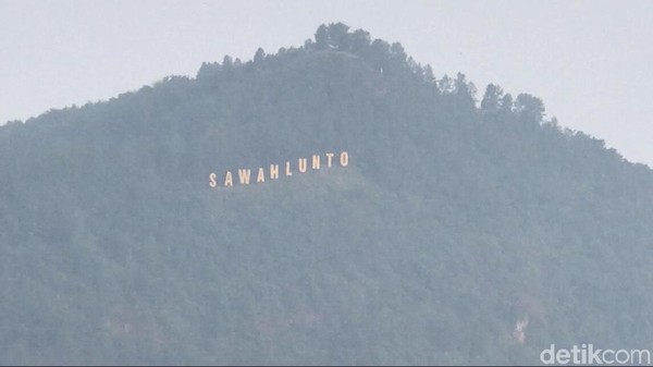 Tulisan Sawahlunto yang biasa terlihat jelas kini samar tertutup kabut. Begitu juga halnya dengan Silo-silo yang tidak terlihat jelas. (Jeka Kampai/detikcom)
