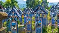 Pemakaman Merry di Rumania. Berbeda dengan pemakaman umumnya yang identik dengan monokrom, pemakaman ini justru menghadirkan makam yang penuh warna cerah. Selain itu setiap nisan dicantumkan puisi dan gambar yang berkaitan dengan orang yang dimakamkan (iStock)