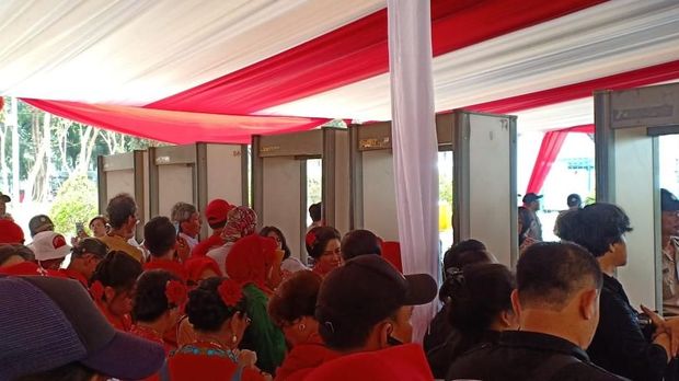 Relawan Jokowi diperiksa menggunakan metal detector.