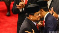 Prabowo tampak memeluk Jokowi.