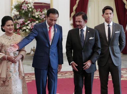 Indonesian President Joko Widodo, second left, directs Brunei's Sultan Hassanal Bolkiah, second right, as Widodo's wife Iriana, left, and Bolkiah's son Abdul Mateen look on during their meeting ahead of Widodo's inauguration, at Merdeka Palace in Jakarta, Indonesia, Sunday, Oct. 20, 2019. (AP Photo/Dita Alangkara)