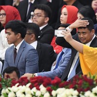 Pria kelahiran 25 Desember 1994 itu lalu memadukan setelan tersebut dengan kemeja putih sebagai dalaman. Dasi berwarna gelap ikut melengkapi gayanya. Foto: ANTARA FOTO/Akbar Nugroho Gumay/hp