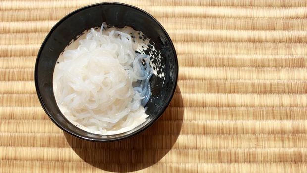 Shirataki noodles in black plate placed on Japanese traditional Tatami flooring mat